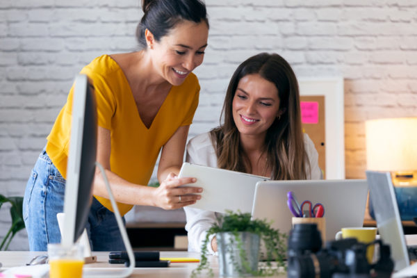 CheckCars24 | Shot of two young businesswomen talking